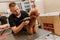 Professional male groomer making haircut of poodle teacup dog at grooming salon with professional equipment