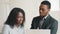 Professional male mentor teacher helping african american female intern with corporate software online job course at