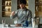 Professional man bartender stirring ice in the glass on the bar counter