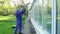 Professional man cleaning dirty windows with high pressure water jet