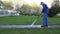 Professional man using power washer tool on footpath.