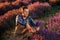 Professional man worker in uniform Cutting Bunches of Lavender with Scissors on a Lavender Field. Harvesting Lavander Concept