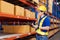 Professional Man Worker wearing hard hat checks stock and inventory with Clipboard in the retail of shelves with goods