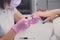 Professional manicure process in beauty salon. Closeup manicurist applies nail polish