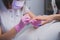 Professional manicure process in beauty salon. Closeup manicurist applies nail polish