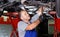 Professional mature man car mechanician repairing car in auto repair shop