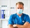 Professional medical doctor in hospital office, Portrait of young and confident physician in protective mask.