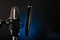 Professional microphone and pop filter. Dark blue background. Minimalism. No people. Recording studio, clear sound, singing, radio