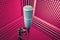 Professional microphone in sound recording studio, purple acoustic foam background