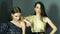 Professional models with chic make-up in dresses on one shoulder poses at photo shoot