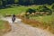 A professional motocross rider exhilaratingly riding a treacherous off-road forest trail on their motorcycle.