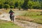 A professional motocross rider exhilaratingly riding a treacherous off-road forest trail on their motorcycle.