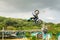 A professional motorcycle rider giving a free style motorcross acrobatics demonstration in Shenzhen Zoo park, in China