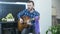 Professional musician giving online performance, playing on acoustic guitar and singing ballads at home. Solo guitarist play chord