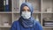 Professional Muslim medical doctor works in hospital office. Young and attractive Middle Eastern female physician in