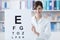 Professional oculist holding an eye chart