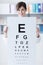 Professional oculist holding an eye chart