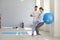 Professional osteopath controlling womans position during exercising with fitness ball