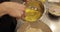 A professional pastry chef woman mixes eggs and adds them to a large bowl