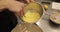 A professional pastry chef woman mixes eggs and adds them to a large bowl