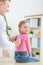 Professional pediatrician examining little girl