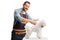 Professional pet groomer holding scissors and grooming a bichon frise dog