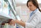 Professional pharmacist near shelves with merchandise in drugstore