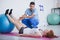 Professional physiotherapist and sportswoman on mat exercising with ball