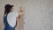 Professional plasterer female spackles the wall, applies and spreads plaster on a spatula in overalls and ball cap