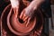 Professional potter making bowl in pottery workshop, studio.