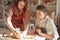 Professional potter teaching pottery to a woman