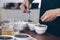 professional Q Grader preparing to test and inspecting the quality of coffee and skim off the coffee grounds from ceramic cup on