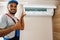 Professional repairman installing air conditioner in a room