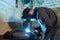 Professional repairman welding motorbike fuel tank part