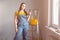 Professional repairwoman doing a home renovation, she is posing and holding a drill.