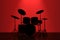 Professional Rock Drum Kit with Red Backlight in front of Wall.