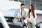 Professional salesperson selling cars at dealership to buyer