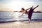 Professional Sensual Japanese Ballet Dancer in Black Tutu And Silver Crown Posing Near Seashore During Ballet Pas With Lifted