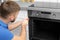 Professional serviceman repairing modern oven