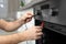 Professional serviceman repairing modern oven in kitchen