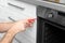 Professional serviceman repairing modern oven in kitchen.