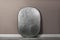 Professional silver reflector near grey wall in room. Photography equipment