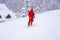 Professional ski instructor lifting on the ski drag lift rope to the mountain during snowfall. Family and children