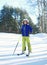 Professional skier child boy in sportswear helmet on ski winter, snowy day on hill mountain over forest