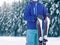 Professional skier sportsman teenager in sportswear standing with ski on winter snowy forest