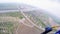 Professional skydiver fly above green flatland, river. Blue suit. Landscape.