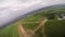 Professional skydiver fly in sky above green field in countryside. Sunny day.