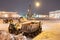 Professional snow removal equipment clearing Palace Square at night after intense snowfall in city