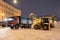 Professional snow removal equipment clearing Palace Square at night after intense snowfall in city