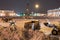 Professional snow removal equipment clearing Palace Square at night after intense snowfall in city